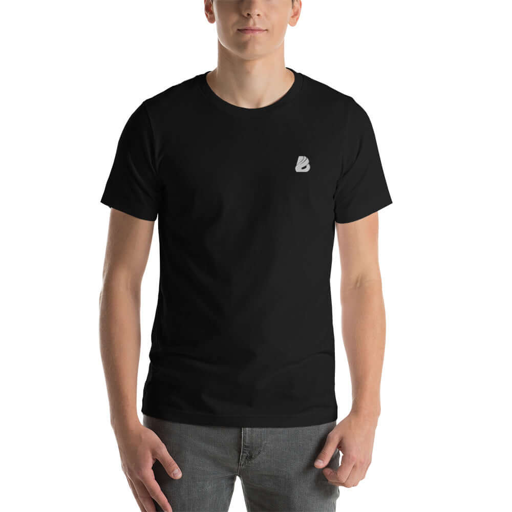 Man wearing a black Kurzärmeliges Unisex-T-Shirt N°4 with a small logo on the chest