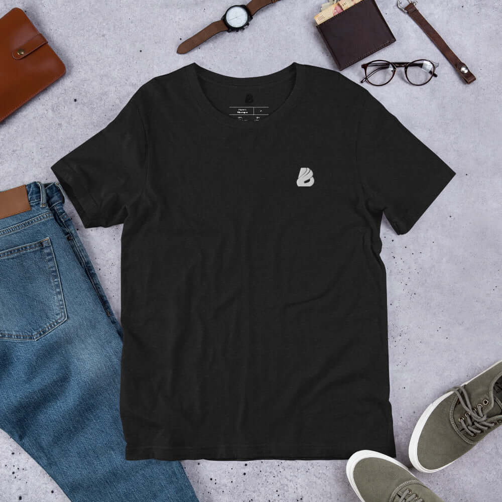 Kurzärmeliges Unisex-T-Shirt N°1 in Schwarz auf einem Tisch neben Jeans und Accessoires, perfektes Baumwollhemd für Komfort und Stil.