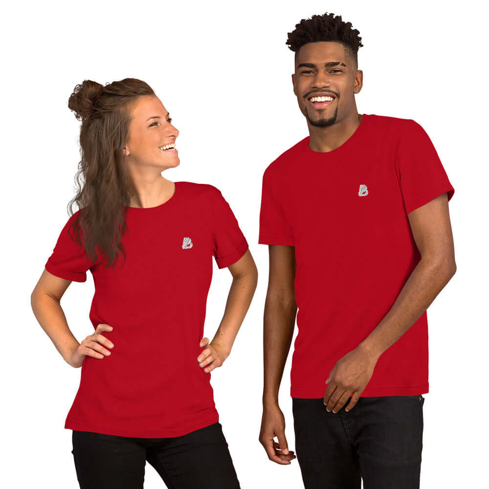 Two models wearing red Kurzärmeliges Unisex-T-Shirt N°1, smiling with hands on hips.