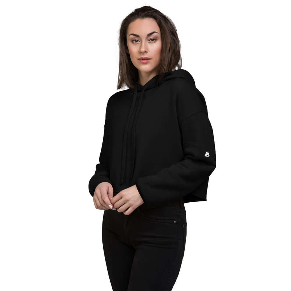 Woman wearing a Crop-Hoodie N°0 in black with raw hem and matching drawstring, showcasing the trendy and comfortable design.