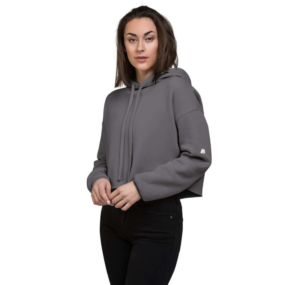 Woman wearing Crop-Hoodie N°0 with raw hem and matching drawstring, 52% Airlume cotton, 48% polyester fleece, stylish fashion.