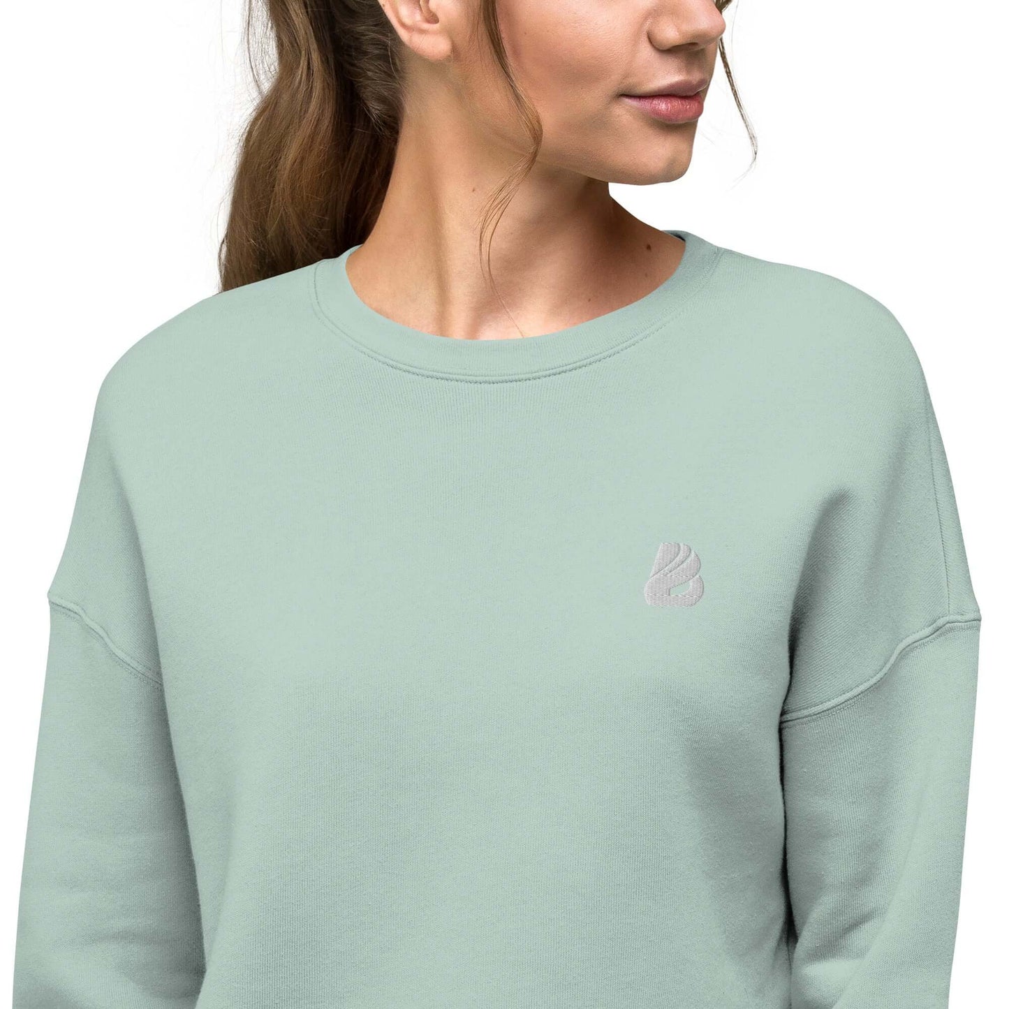 Woman wearing Crop-Pullover N°0, soft fleece with ribbed neckline and raw hem, combining fashion and comfort in mint green.