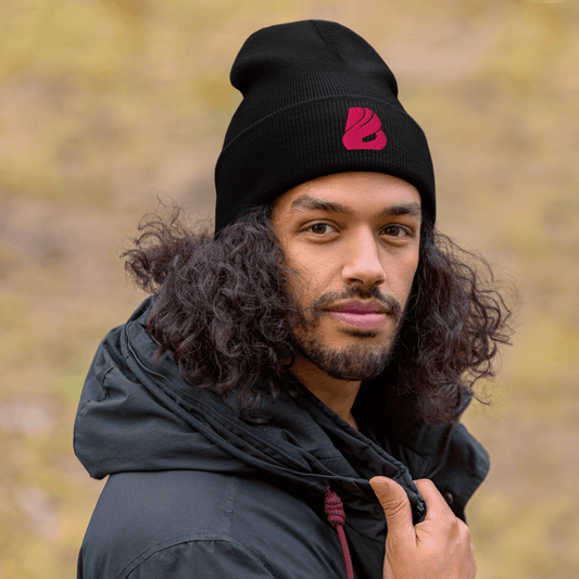 Mann mit lockigem Haar trägt eine schwarze Mütze mit BONBOZZ® Logo, lässiger Look in der Natur.