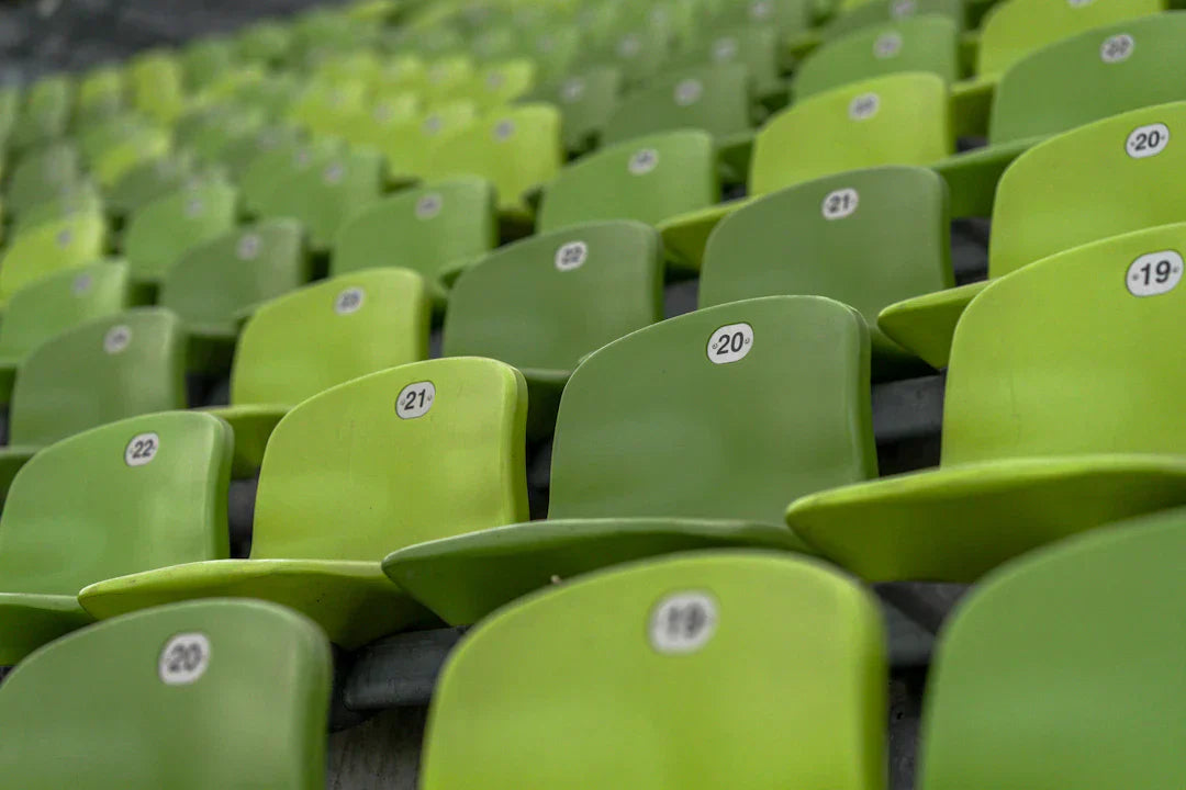 Rows of empty green stadium seats numbered from 19 to 21, showcasing a vibrant seating arrangement.