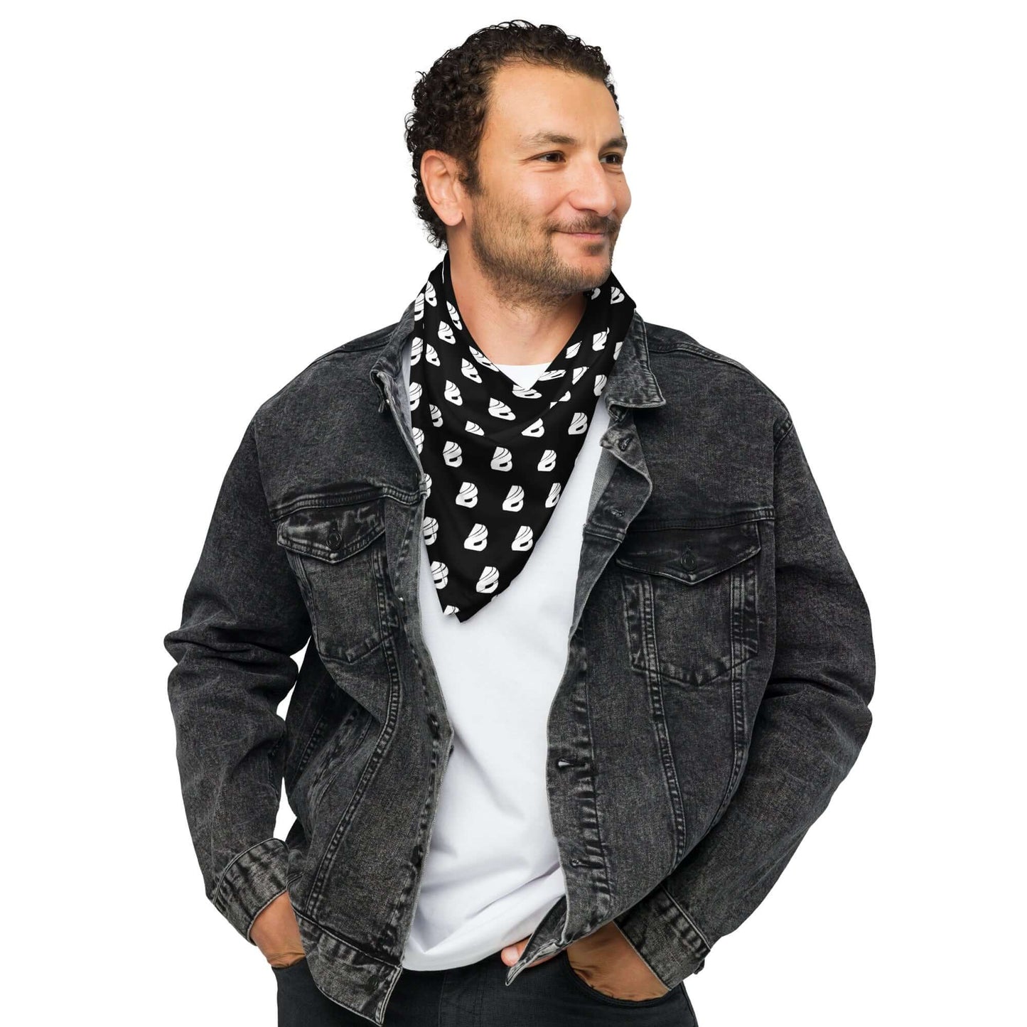 Smiling man wearing a stylish allover-print Bandana as a neck accessory with a black denim jacket.