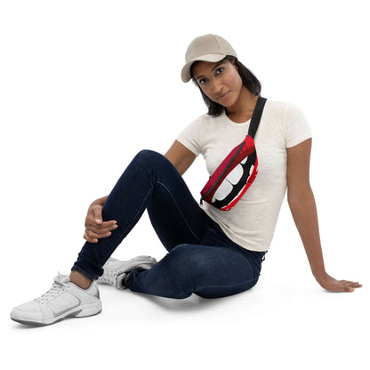 Woman wearing Gürteltasche N°30 with red lips design, sitting casually in jeans and sneakers, showcasing adjustable strap and compact size.