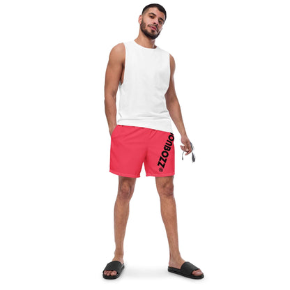 Model wearing Herren-Badehosen N°13, red swim shorts with black lettering, showcasing quick-drying, breathable fabric perfect for summer.