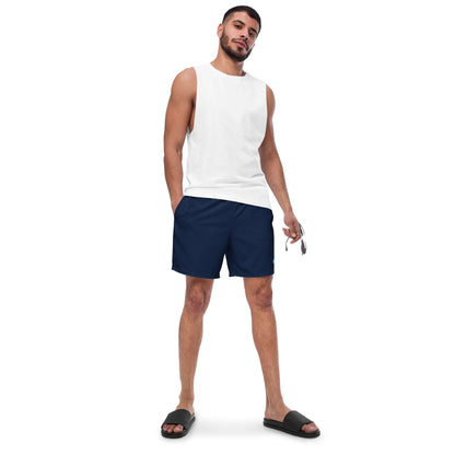 Man wearing Recycelte Schwimmshorts, ideal for summer with quick-dry and breathable features, navy color, paired with white tank top.