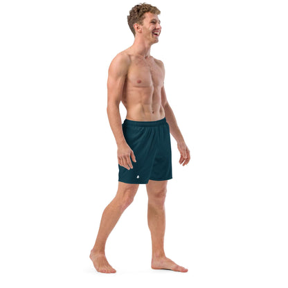 Man wearing Herren-Badehosen N°15, dark blue swim shorts, standing and smiling, showcasing quick-dry and breathable fabric.