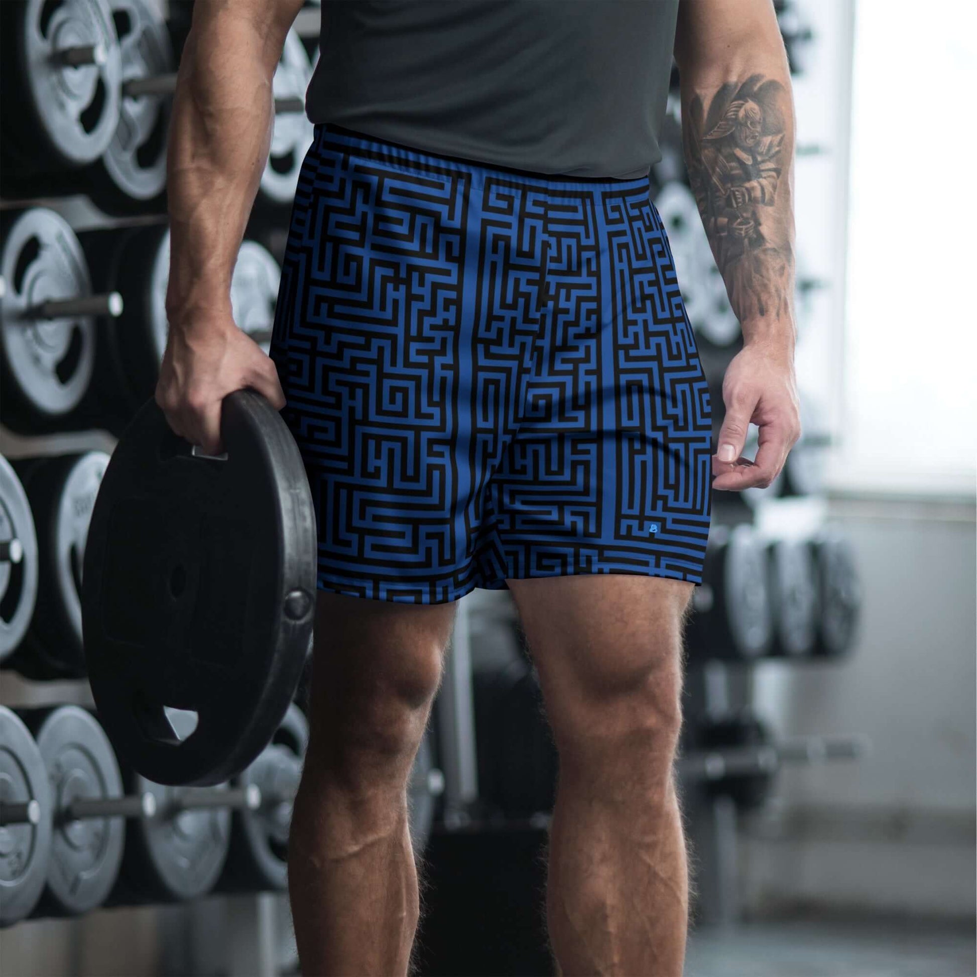 Lange Unisex Sport-Shorts worn by person lifting weights in gym, featuring blue maze pattern, made of recycled polyester and elastane.
