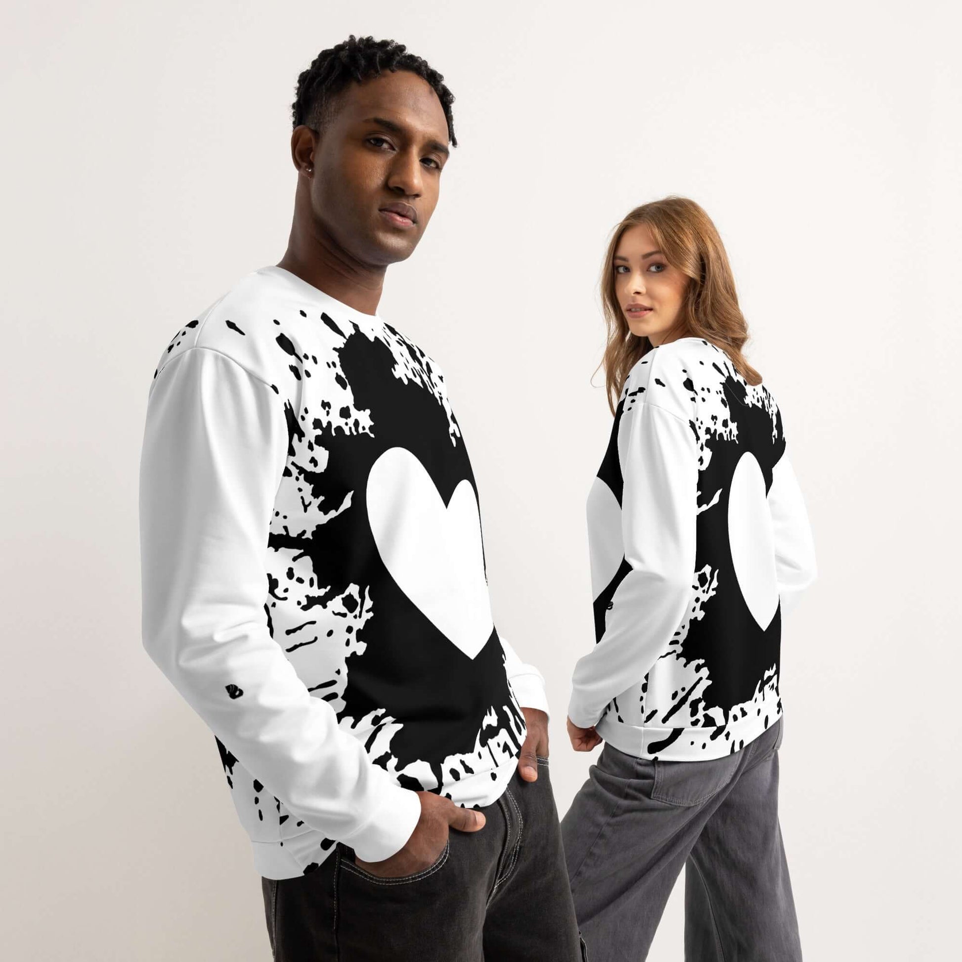 Two models wearing black and white sweatshirts with heart design, showcasing casual streetwear fashion.