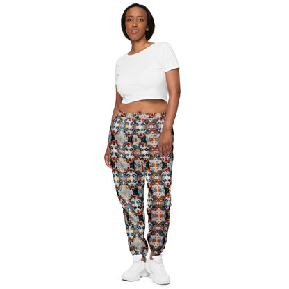 Model wearing Unisex-Trainingshose N°0 with colorful patterns, highlighting the lightweight, water-repellent material and elastic ankles.