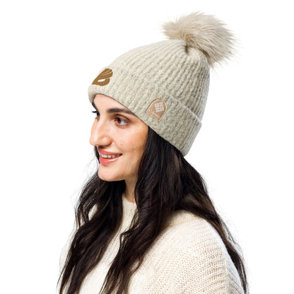 Woman wearing Columbia Bommelmütze with faux fur pom-pom, featuring soft microfleece lining, ideal for winter style.