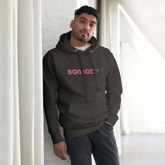 Unisex-Kapuzenpullover in dunklem Grau mit Aufdruck, Modell steht an Wand gelehnt. Streetwear mit Beuteltasche und Kapuze im modernen Design.