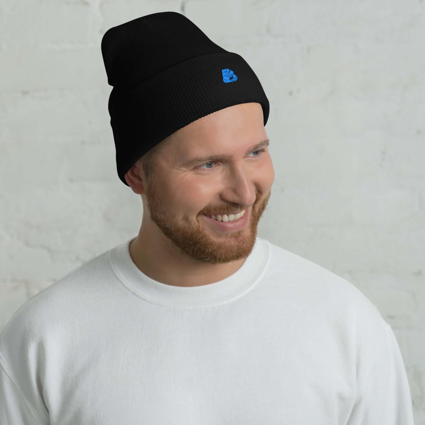 Umgeschlagene Beanie aus schwarzem Acryl, unisex, hypoallergen, zeigt Mann lächelnd. Kuschlige, warme Mütze für jeden Stil.