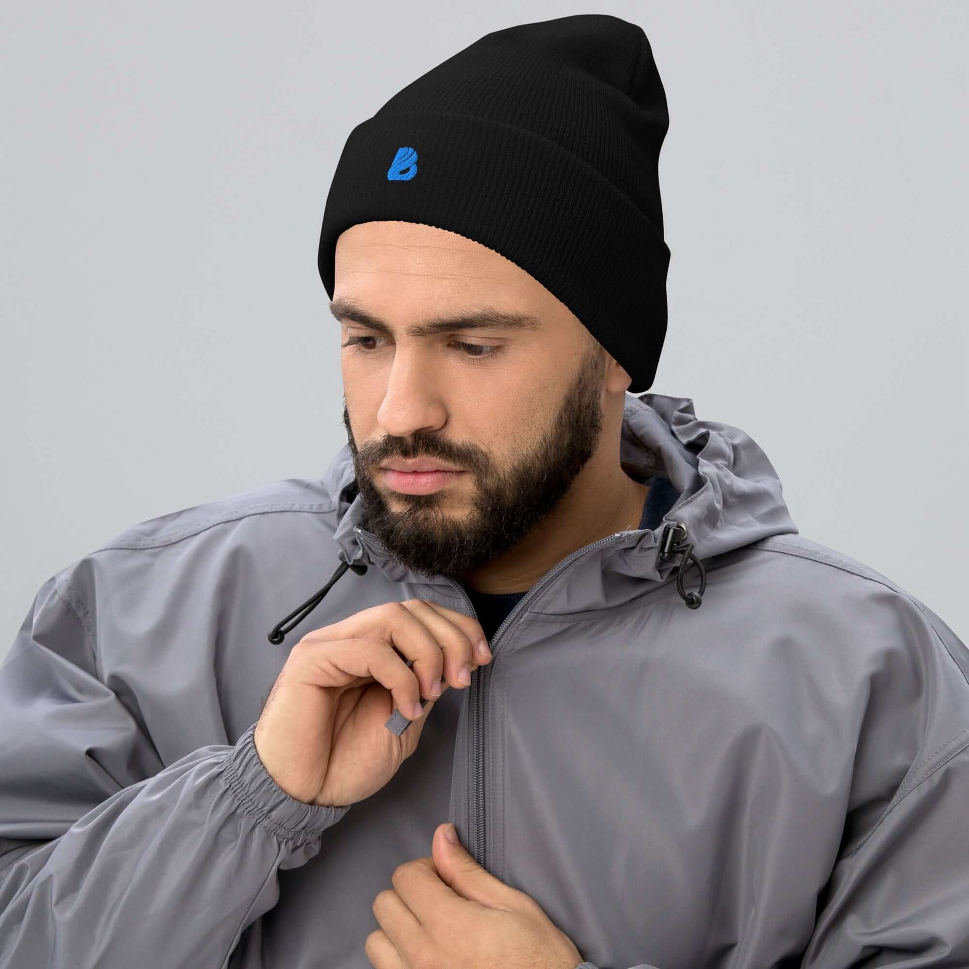 Mann trägt schwarze Umgeschlagene Beanie aus 100 % Acryl, gemütlich und hypoallergen, ideal für kaltes Wetter und moderne Garderobe.