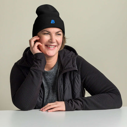 Lächelnde Frau trägt Umgeschlagene Beanie, eine kuschlige und hypoallergene Mütze aus 100% Turbo-Acryl für Wärme und Stil.