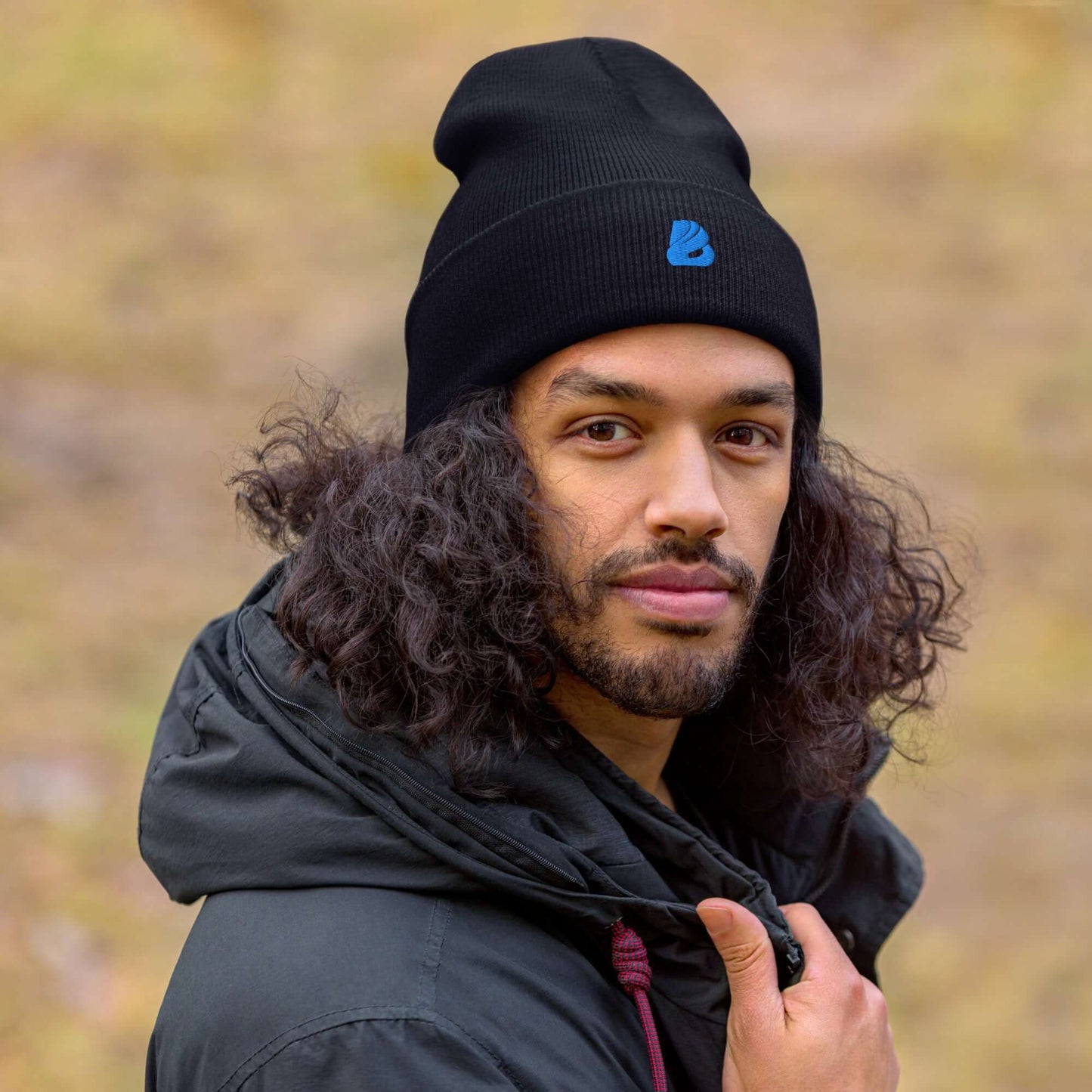 Person wearing a black umgeschlagene Beanie, showcasing its comfortable fit and stylish design in a natural outdoor setting.
