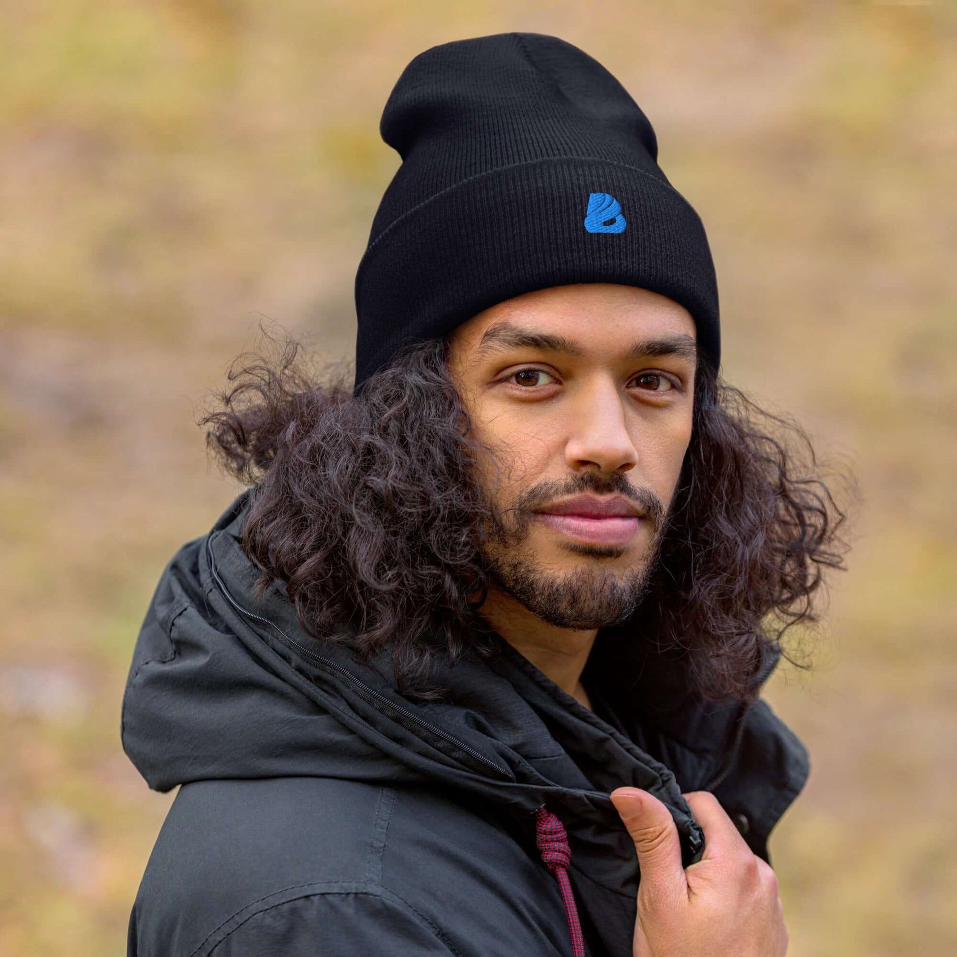 Person wearing a black umgeschlagene Beanie, showcasing its comfortable fit and stylish design in a natural outdoor setting.