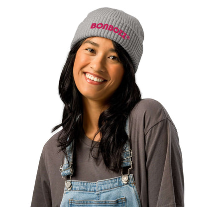 Woman wearing gray beanie with "BONBOZZ" text, styled in denim overalls and a gray shirt, showcasing versatile accessory fashion.