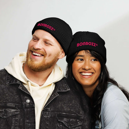 Two people wearing black Fischermütze N°0 beanies with pink logo, showcasing trendy fisherman-style winter hats.