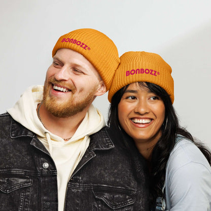Smiling couple wearing orange Fischermütze N°0 hats, showcasing trendy and warm beanie design with BONBOZZ logo.