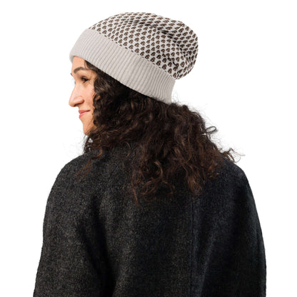 Person wearing a patterned Gestrickte Mütze, showcasing its soft, lightweight fabric, ideal for chilly days, made from cotton and polyester.