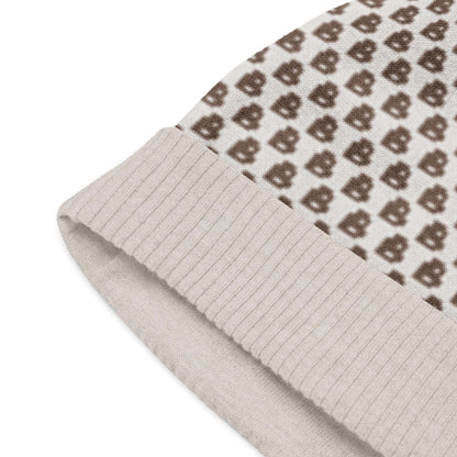 Gestrickte Mütze in beige mit braunem Muster, leicht und weich, maschinenwaschbar, ideal für kühlere Tage, 55% Baumwolle, 45% Polyester.