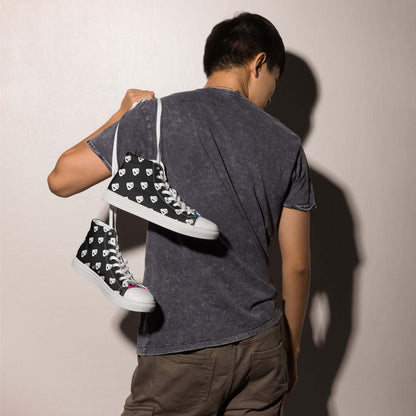 Person holding High-Top Leinenschuhe für Herren N°7 over shoulder, showcasing stylish design and black fabric with white laces.