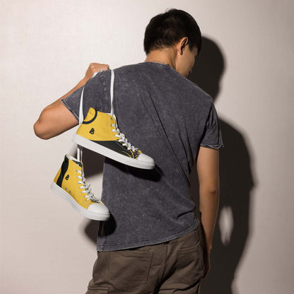 Person holding yellow sneakers with white soles behind back.