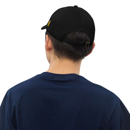 Rear view of person wearing black Bio-Dad Hat N°1 made from 100% organic cotton, showcasing adjustable strap and sustainable fashion.