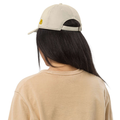 Person wearing a beige Bio-Dad Hat N°1 made from 100% organic cotton, showcasing sustainable fashion.