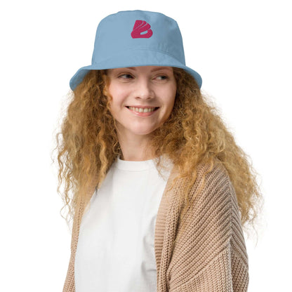 Woman wearing Fischerhut aus Bio-Baumwoll-Twill N°0, stylish eco-friendly hat in blue with red logo