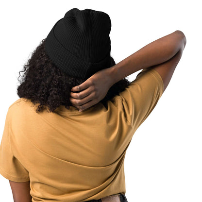 Gerippte Bio-Beanie in schwarzer Farbe auf Frau mit lockigem Haar, zeigt die gerippte Struktur und natürliche Baumwollbeschaffenheit.