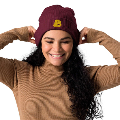 Woman wearing Gerippte Bio-Beanie N°1 made from 100% organic cotton, showcasing ribbed design and eco-friendly material in burgundy color.