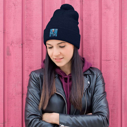 Woman wearing Bommelmütze against a pink wood wall, featuring a pom-pom and leather jacket for a stylish cold-weather look.