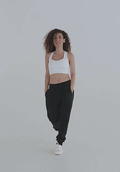 Woman walking in Longline-Sport-BH N°0 and black joggers, showcasing comfort and style suitable for sports or streetwear fashion.