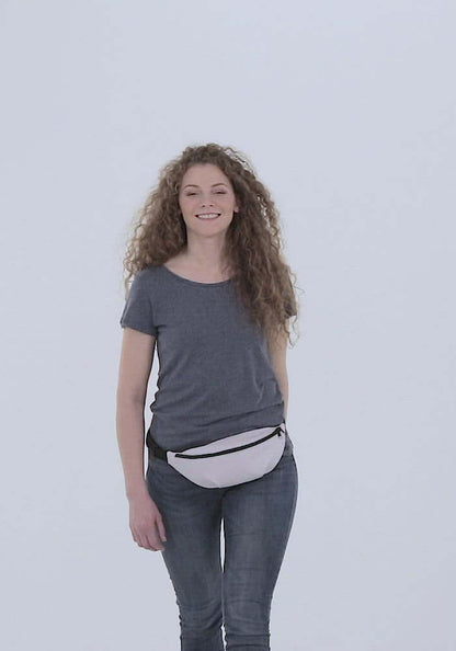 Woman wearing Gürteltasche N°1, a stylish and adjustable belt bag ideal for travel and festivals, featuring an inner pocket and polyester material.