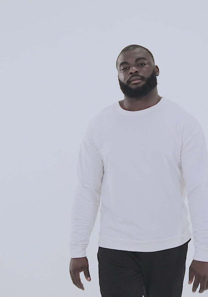 Person wearing a white Unisex-Pullover N°1 showcasing the minimalist design on a neutral background