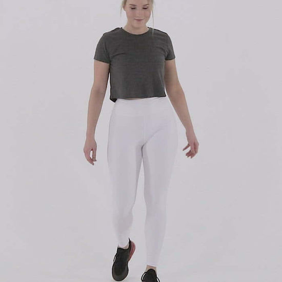 Person wearing white Yoga-Leggings N°3 with high waist, demonstrating stretch and comfort in active pose.