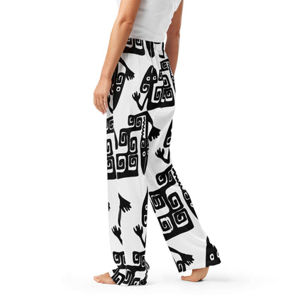 Frau trägt luxuriöse Pyjama-Hose für Damen aus seidigem Material, schwarz-weißes Muster, entspannte Passform