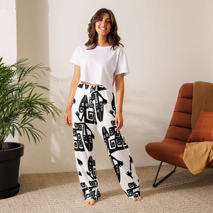 Woman wearing Pyjama-Hose für Damen with graphic print, standing next to a chair and plant, showcasing relaxed loungewear style.