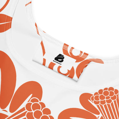 Close-up of orange-patterned Skater-Kleid fabric highlighting neckline and tag detail.