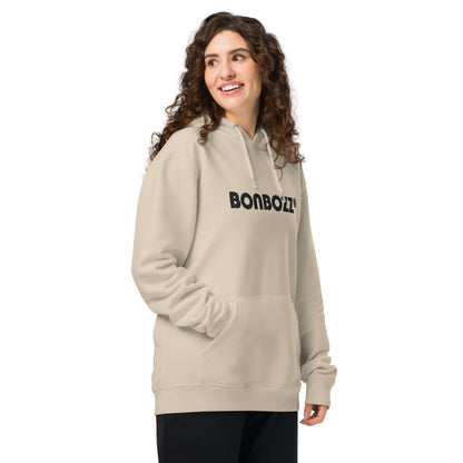 Model wearing Unisex Bio-Hoodie in beige with kangaroo pocket and double-layered hood, showcasing comfort and eco-friendly style.