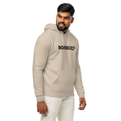 Model wearing beige Unisex Bio-Hoodie with logo, made from organic and recycled materials, combines comfort and streetwear style.
