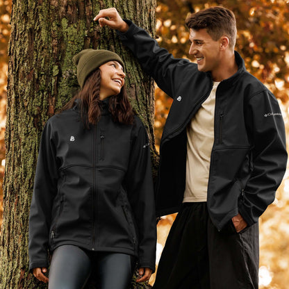 Couple wearing Weiche Columbia Softshell-Jacke N°1 in an autumn forest setting, showcasing outdoor and weather-resistant features.