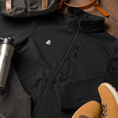 Weiche Columbia Softshell-Jacke N°1, schwarz, mit Reißverschlusstaschen, umgeben von Outdoor-Accessoires auf Holzoberfläche