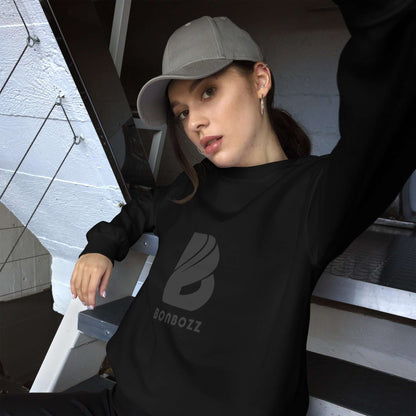 Woman wearing Unisex-Pullover in black, sitting on a staircase, showcasing soft fabric and classic fit for warmth in colder months.