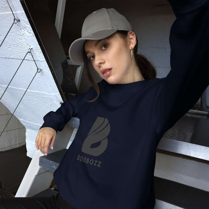 Person wearing a dark blue unisex-pullover sweatshirt with a logo, sitting on stairs and wearing a gray cap.