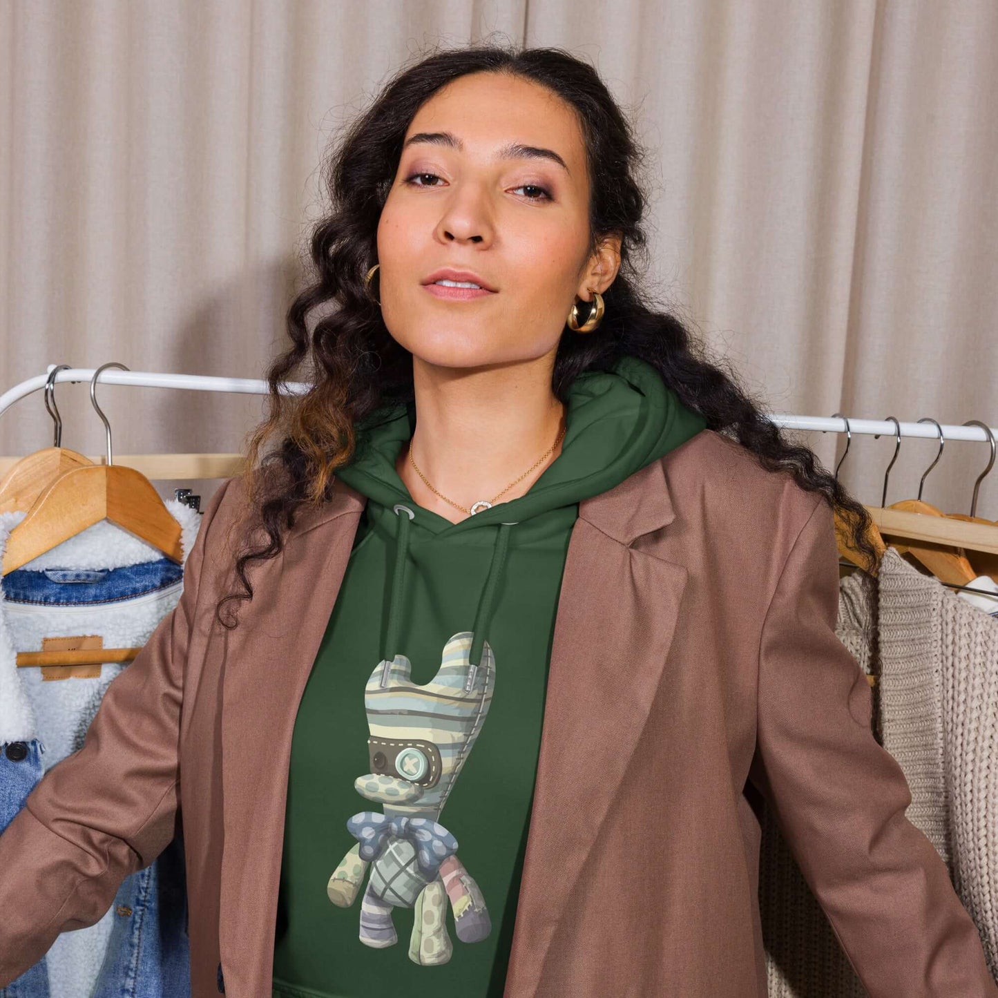 Modell trägt Unisex Bio-Raglan-Hoodie in Grün mit stilvollem Print, kombiniert mit einem braunen Oversize Blazer.